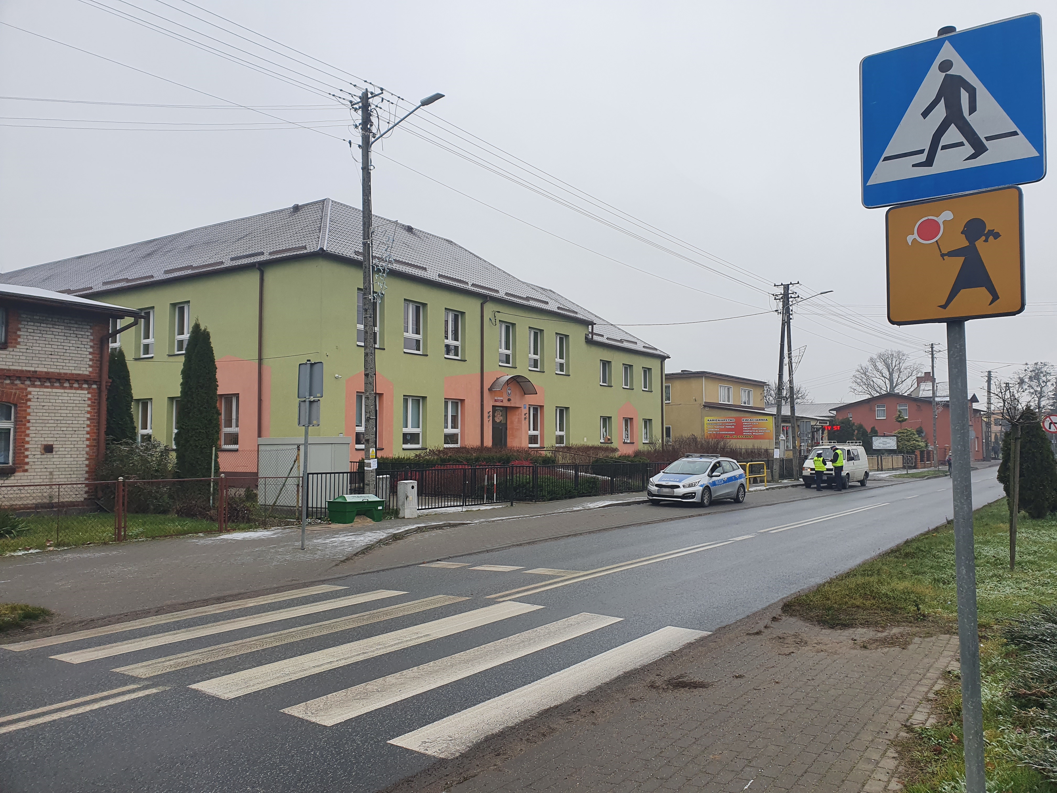 Policjancji kontrolujący auto przed szkołą